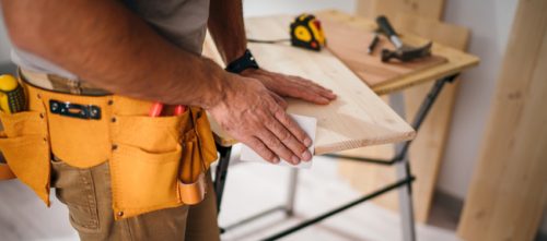 Sanding and smoothing wood with sandpaper.